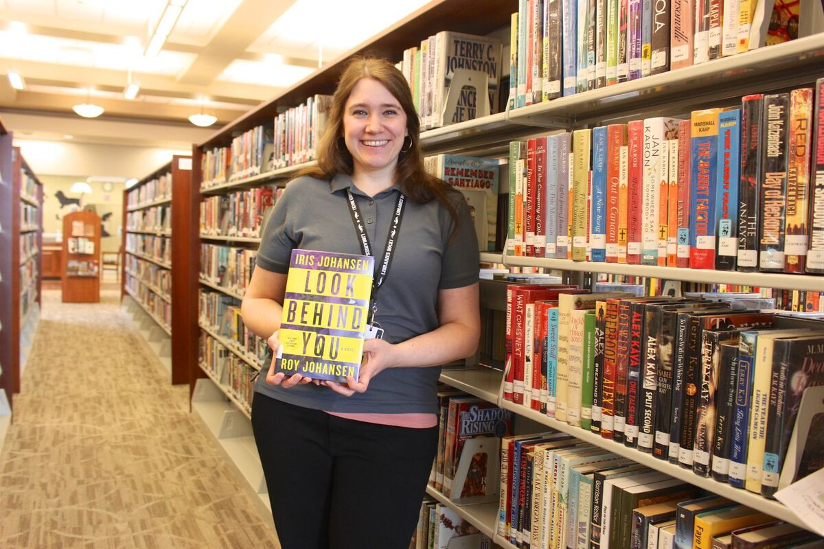 Farmington Public Library's Amber Stearns holds one of the thousands of books adults can choose to read during this summer's first Adult Summer Reading Program. The library assistant has been working hard for months to get ready for the first-time event that will give the participants a chance to win a Kindle Fire.